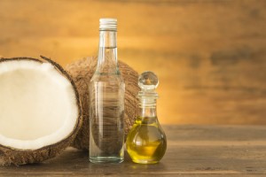 50003584 - coconut oil and fresh coconuts on wooden table.